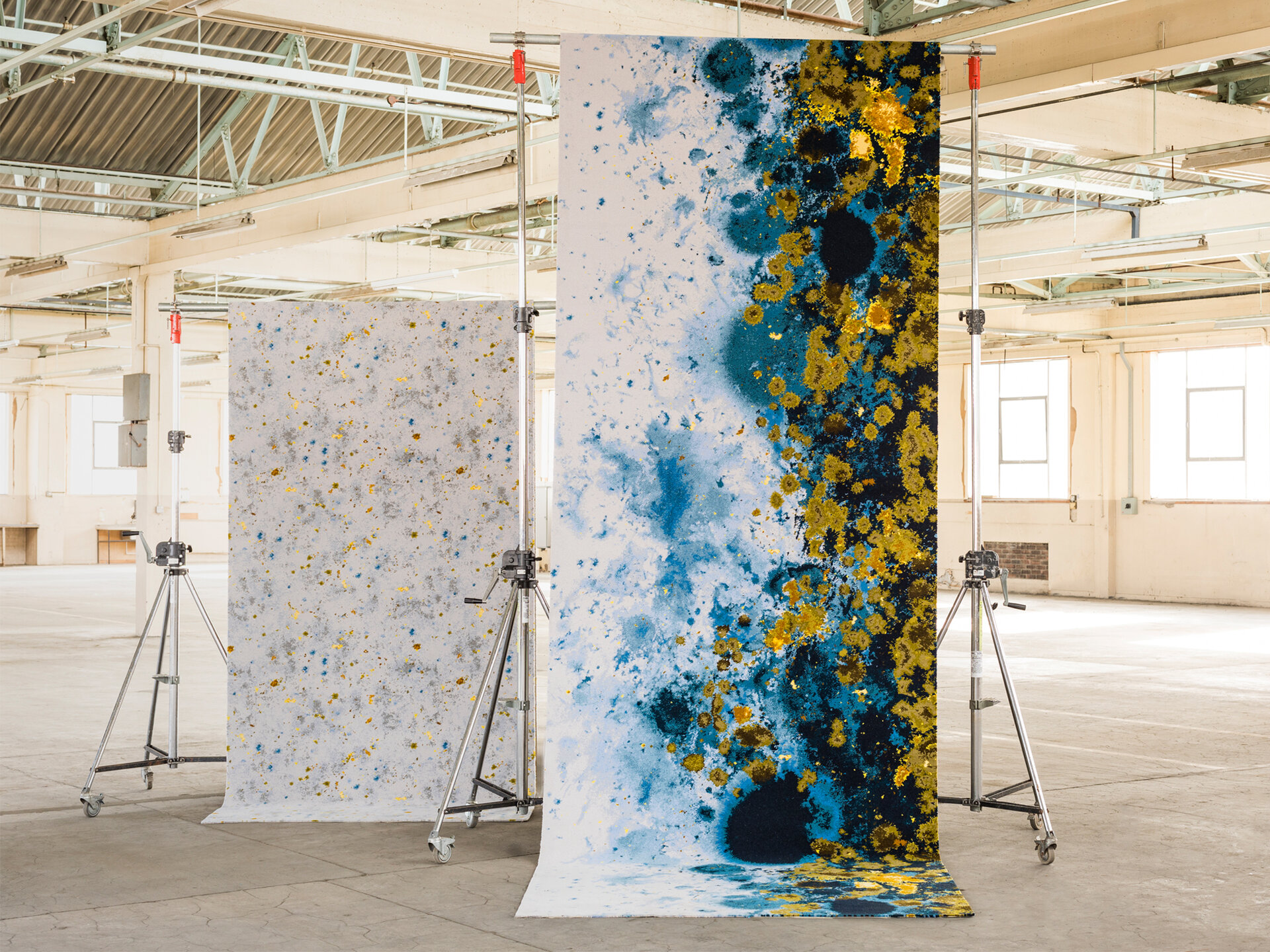 Two carpets in a large room. The carpet in the foreground has a blue and yellow pattern on it.