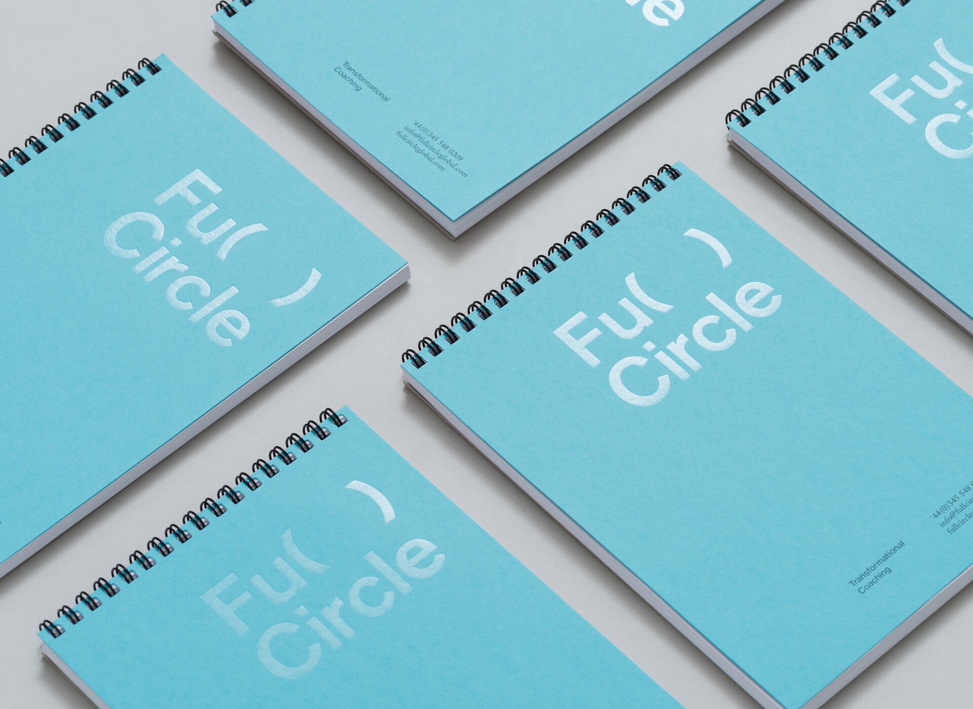 Blue wire bound notebooks with the Full Circle logo on them.