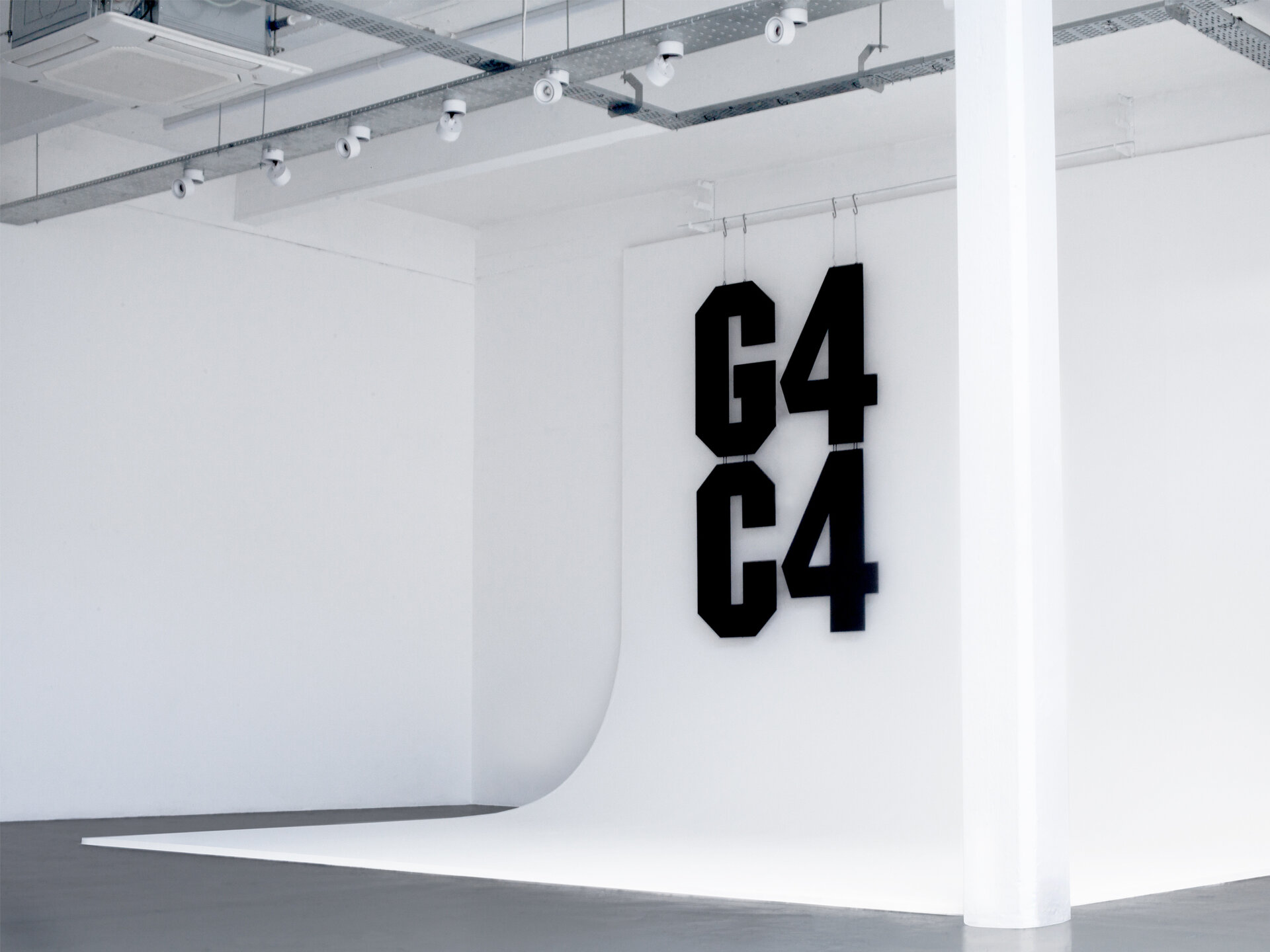A white photographic background with large black angular cut lettering that reads "G4C4"