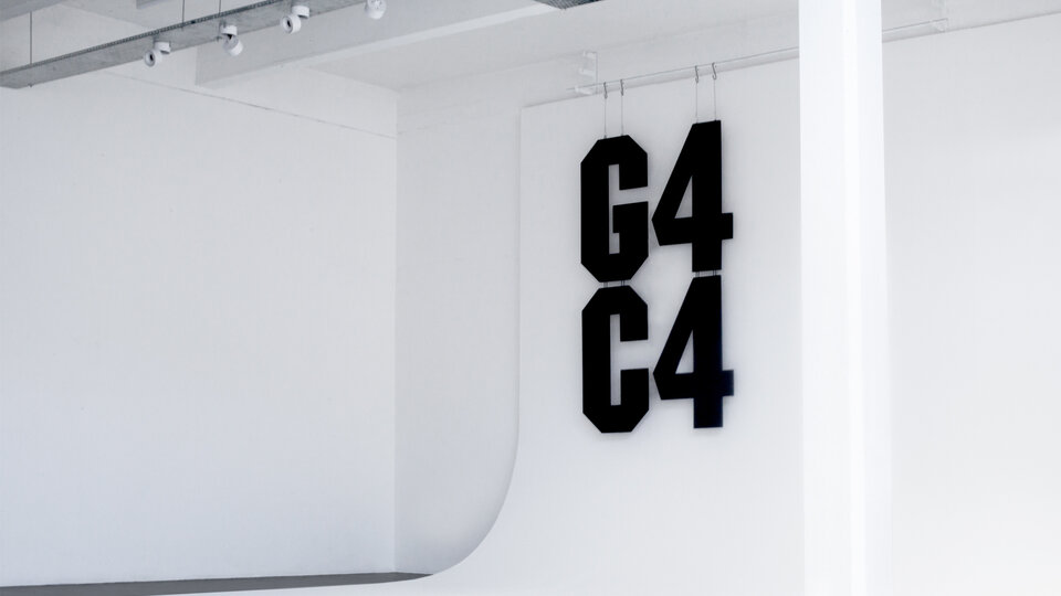A white photographic background with large black angular cut lettering that reads "G4C4"