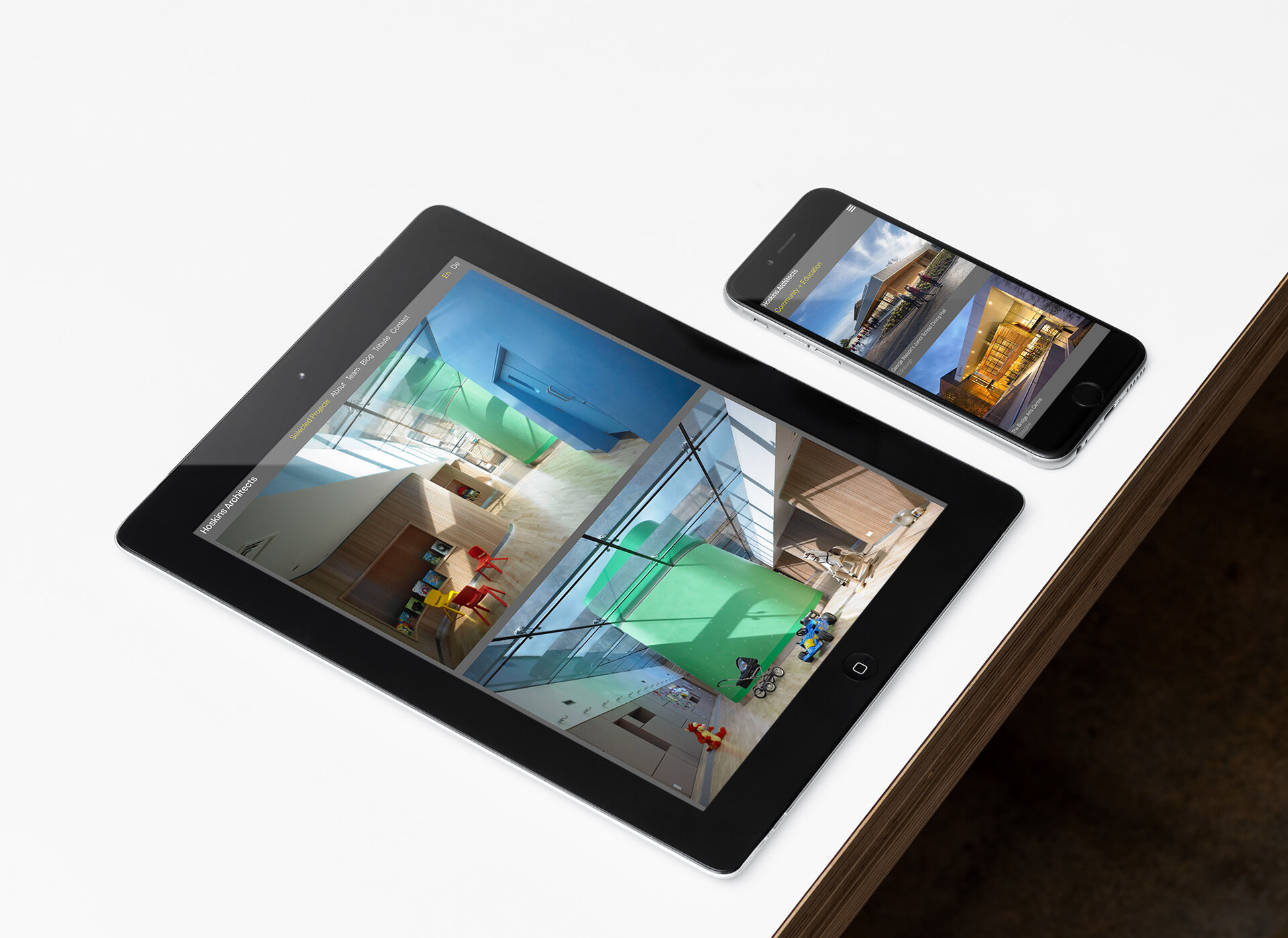 Mock up of website for Hoskins Architects on an iPad and iPhone on a white tabletop.