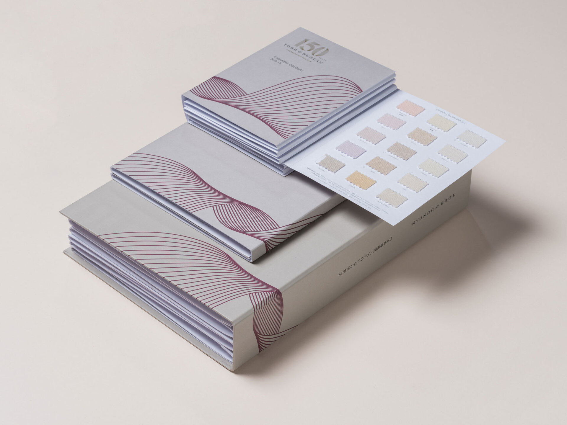 A stack of stationary items including a folder and shade cards sitting on top of each other.