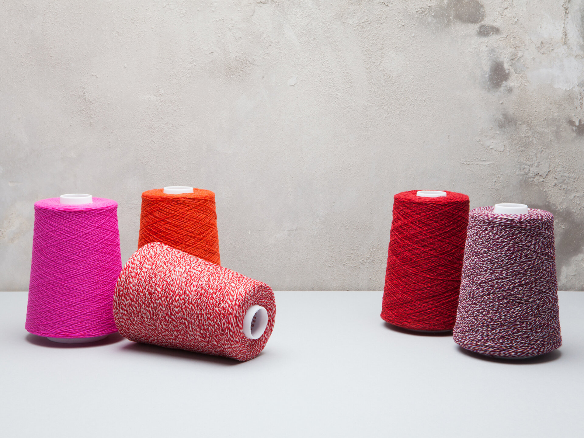 Red, pink and purple shades of fabric on looms.